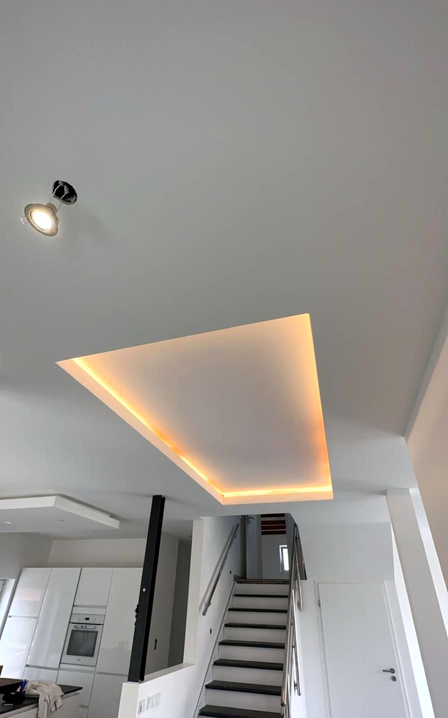 Abgehängtes Deckenfeld mit indirekter LED-Beleuchtung über einer Treppe