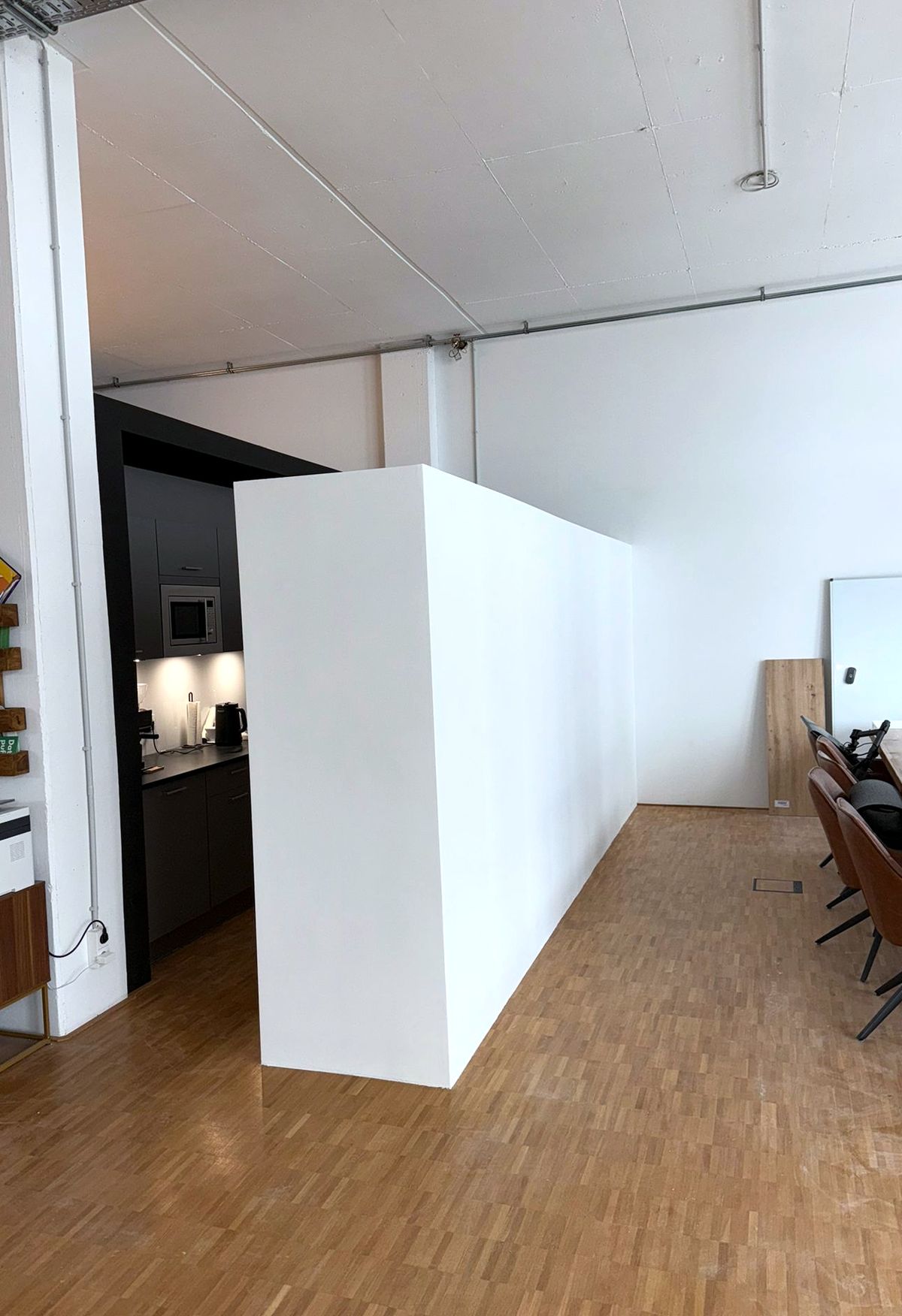 Loft-Büro nachher: freistehende Trockenbauwand trennt die Küche vom Besprechungsbereich