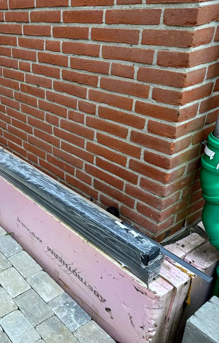 Sockeldämmung mit XPS-Platten an einem Klinkerhaus, im Bau