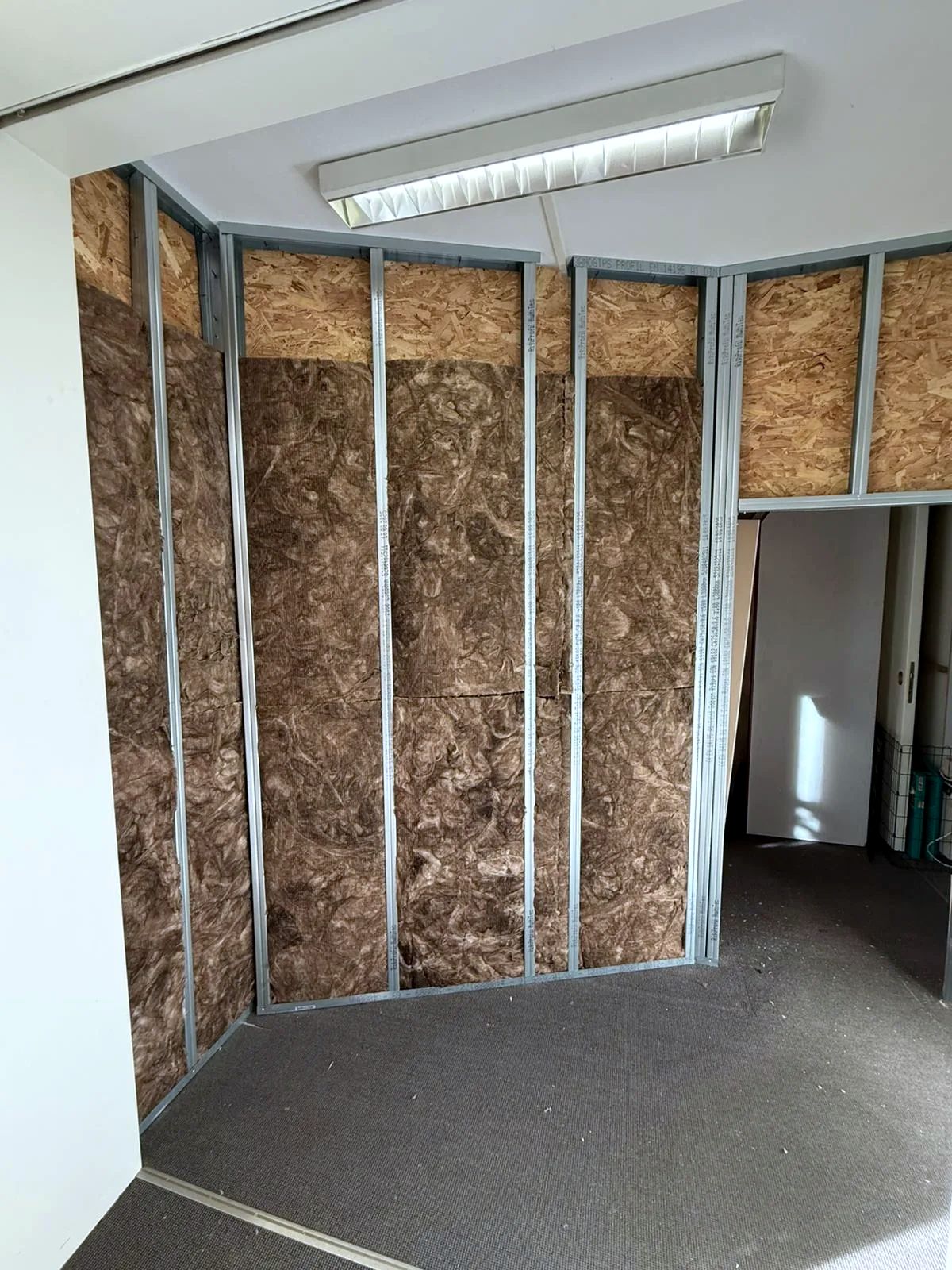 Metallständerwand im Bau: Mineralwolle zwischen den Profilen, OSB-Platten oben